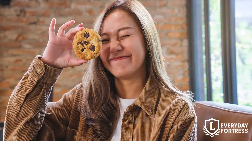 Smiling woman holding a cookie, symbolizing website cookie consent with a light, friendly tone