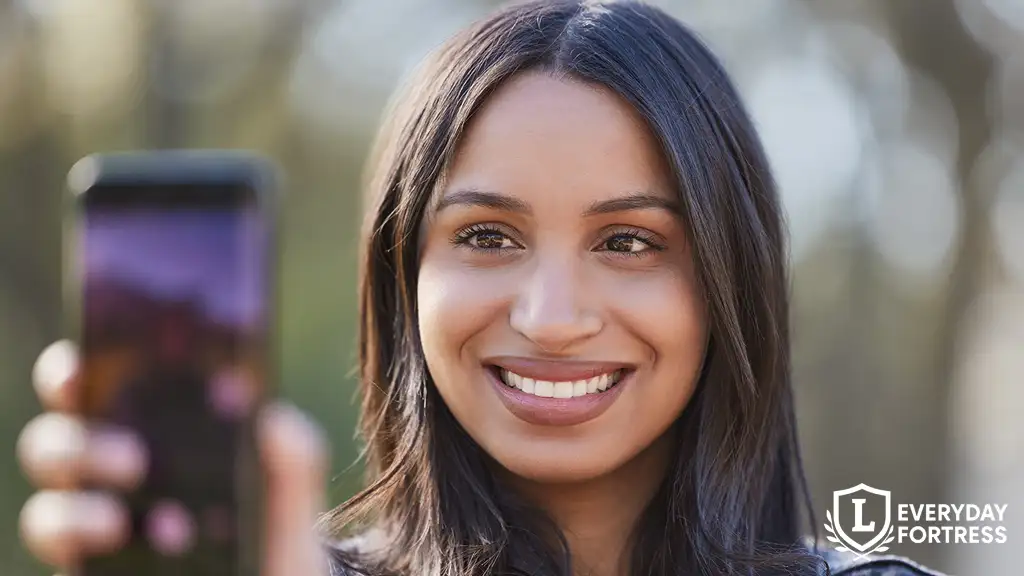 Young woman unlocking phone with facial recognition